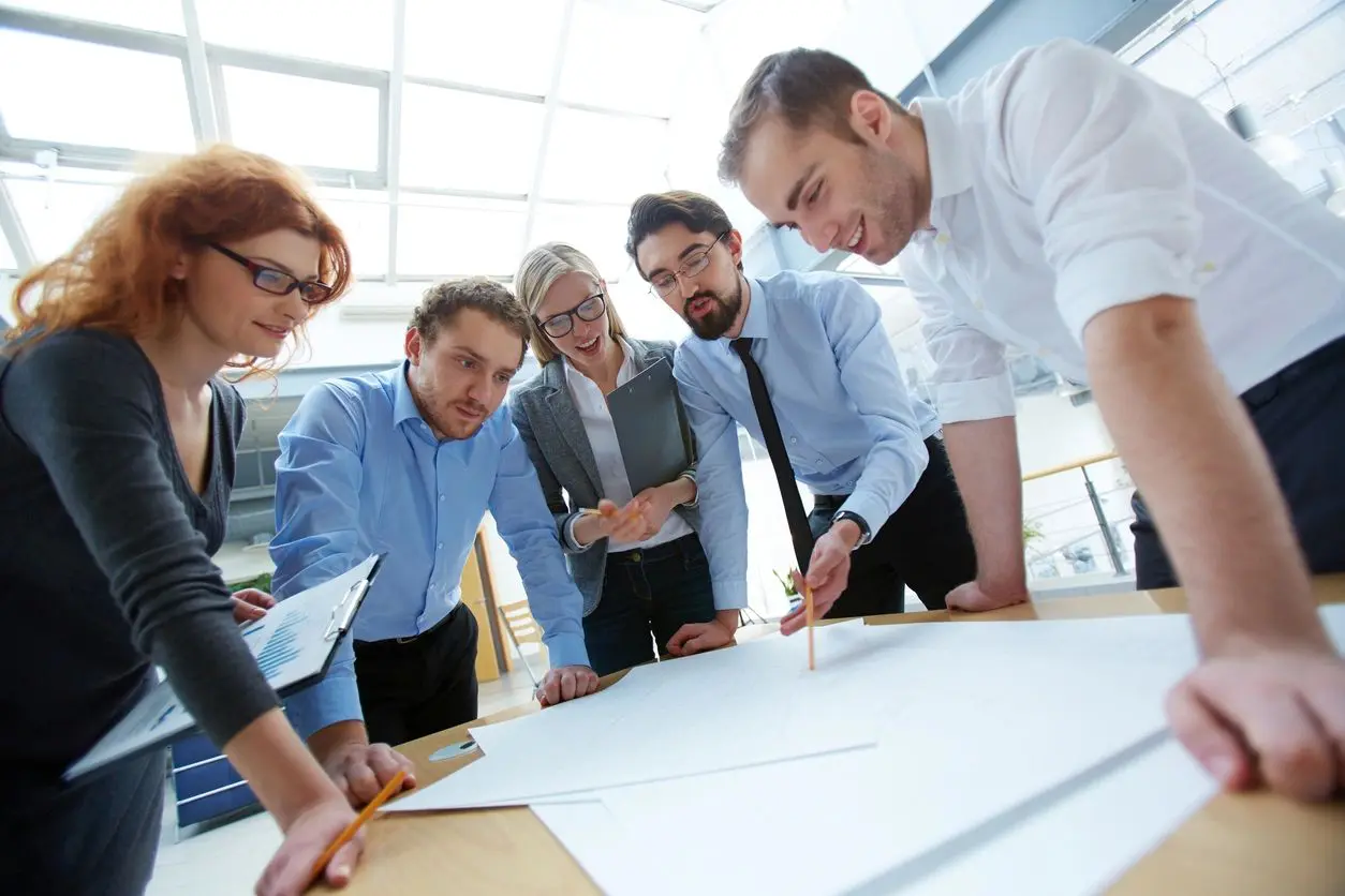 A group of people standing around a table.